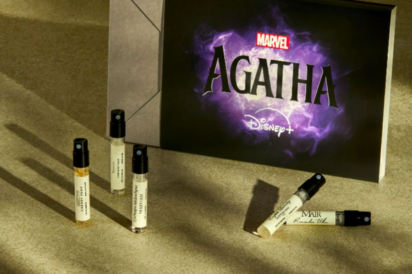 Marvel's Agatha Disney+ show promotional box with perfume sample vials, set against a textured green background.