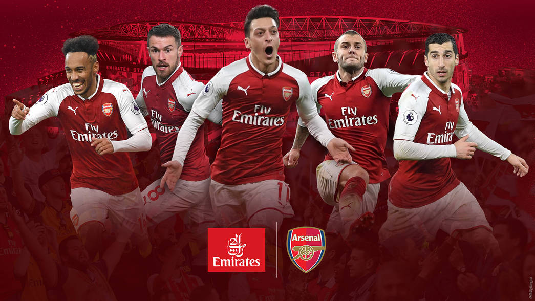 Arsenal FC players celebrating in Emirates-branded jerseys; stadium against red background.